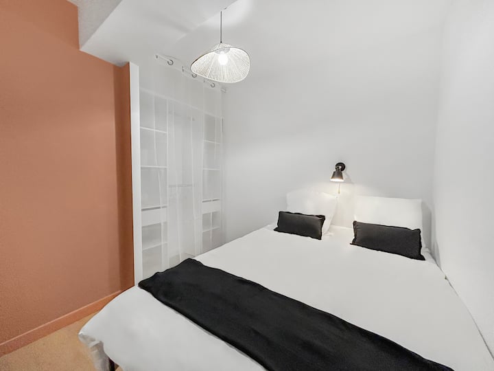 Ova druga spavaća soba ima bračni krevet s praktičnim prostorom za odlaganje. Minimalistički i elegantni ukrasi pružaju opuštajuću atmosferu.