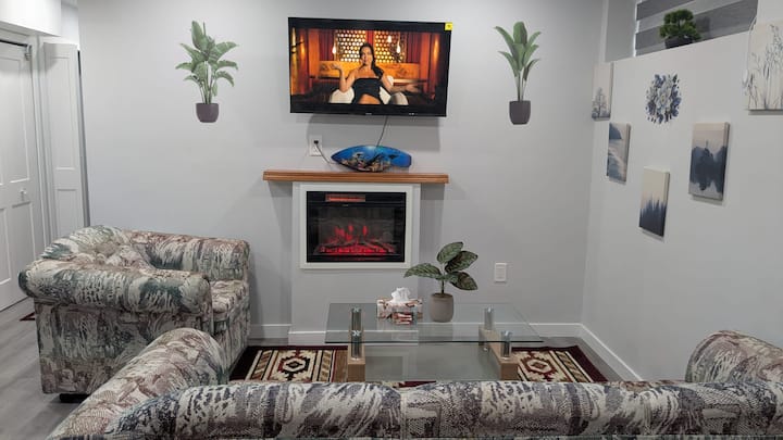 Una sala de estar espaciosa y cómoda con una chimenea interior, una mesa de centro, un sofá de 3 plazas y un sofá de 1 asiento