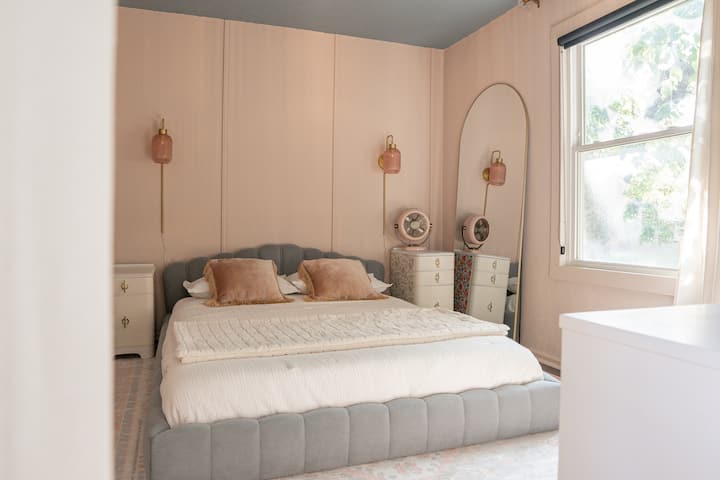 This serene & stylish primary bedroom features 100% percale weave cotton sheets, ensuring a luxurious and cool night's sleep. Enjoy the comfort of memory foam pillows and the unique charm of custom light fixtures that elevate this calming retreat.