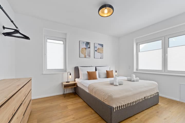 Modern bedroom with cozy box spring bed (180x200 cm), stylish details and plenty of natural light – ideal for relaxing after a day in Bad Kreuznach. Perfect for couples, families, groups of friends or solo travelers.