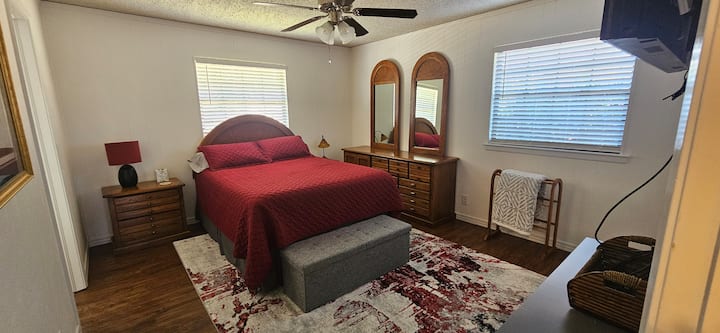 ห้องนอนหลักมีเตียงควีนไซส์ห้องน้ำในตัวทีวีตู้เสื้อผ้าพัดลมเพดานและตู้เสื้อผ้า 