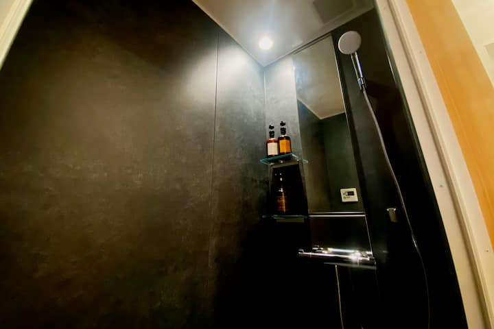 シャワールームには、シャンプー、コンディショナー、ボディーウォッシュを備え付けております。
ボディータオルなどのアメニティは、洗面台横の茶色の棚にございます。