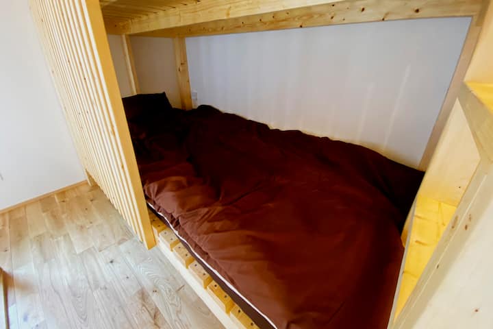 二段ベッドの一段目。枕元にはライトとコンセントもございます。