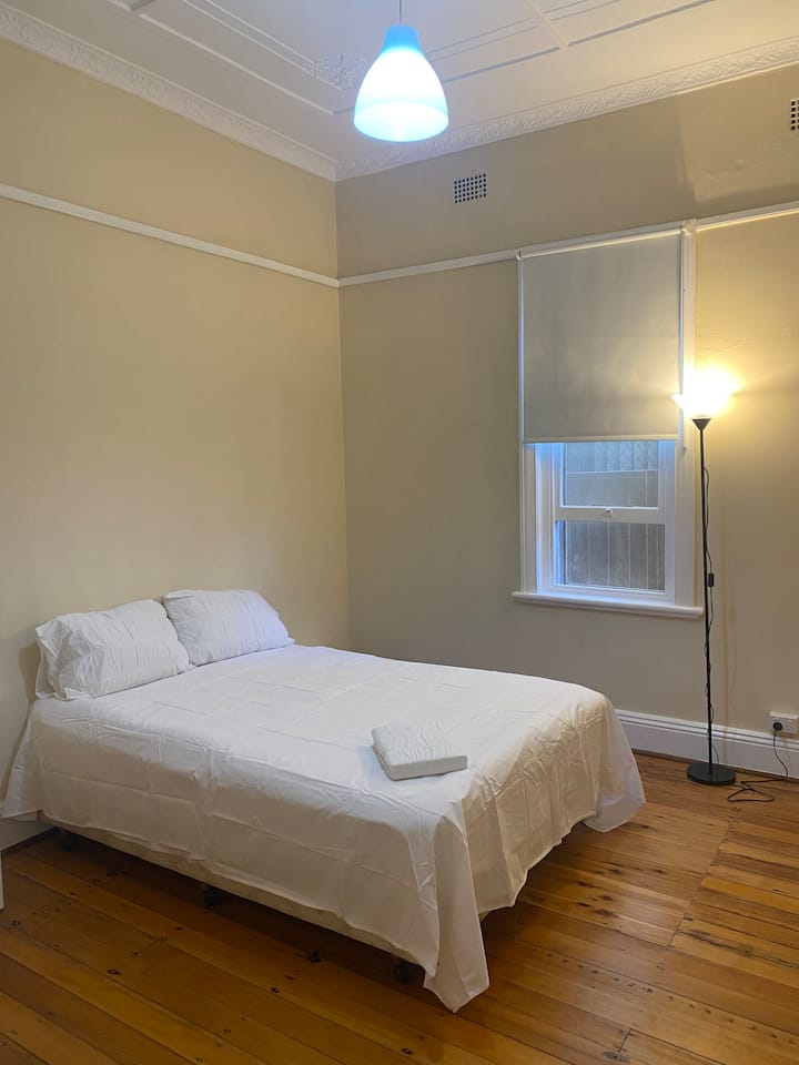 
Ეს ნათელი და მშვიდი საძინებელი გთავაზობთ ორადგილიან საწოლსა და მაღალ ჭერს, რაც ღია, ჰაეროვან შეგრძნებას ქმნის. Ბუნებრივი სინათლის ნაკადი და გაპრიალებული ხის იატაკი სტუმრებისთვის მშვიდი დასვენებაა. Იდეალურია მათთვის, ვინც აფასებს სიმარტივესა და კომფორტს.