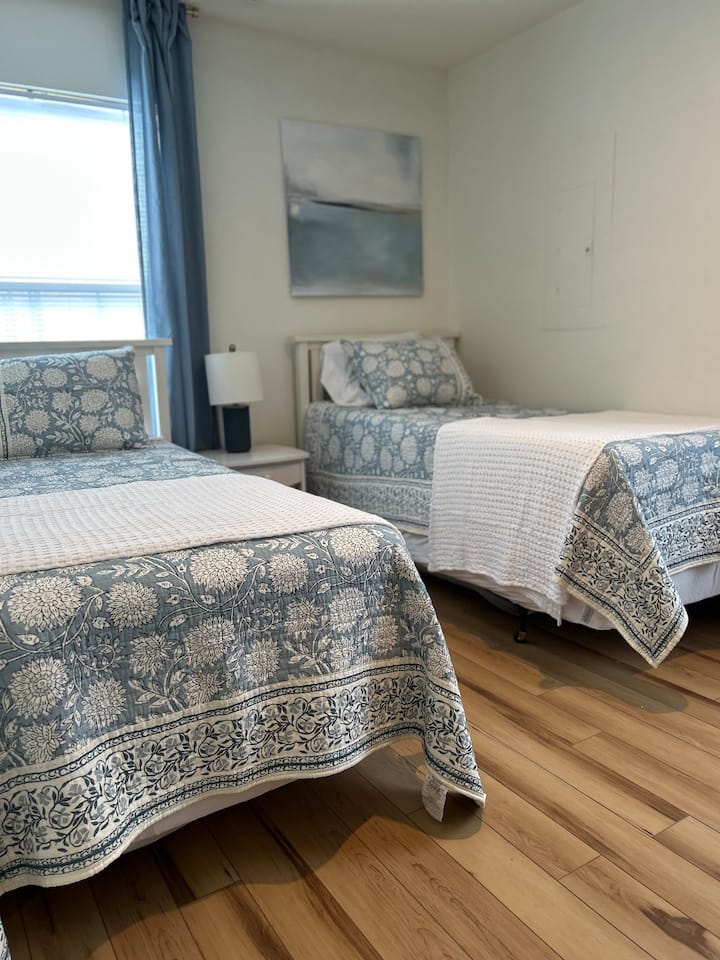 חדר שינה 2 כולל שתי מיטות נפרדות, ארון ושידה.