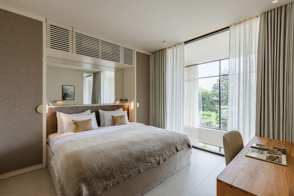 Dhomë gjumi kryesore me dritare panoramike dhe një krevat "king-size"