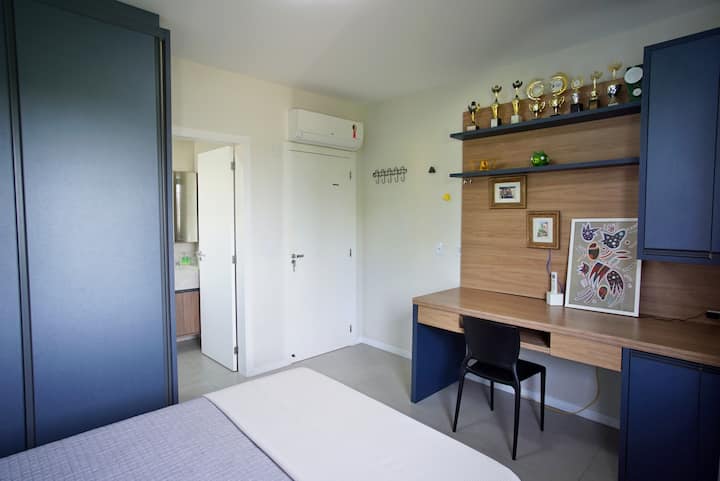 Chumba chenye kitanda cha watu wawili, kiyoyozi, kaunta ya ofisi ya Nyumba na mwonekano wa mtaa.