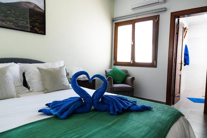 De 'groene' slaapkamer met een eigen badkamer gaat via de achterkant naar de tuin. Het beschikt over airconditioning, insectenschermen en verduisterende schaduw. Er is hier een eigen tv, die kan worden gebruikt met de eigen streamingdiensten van de klant.