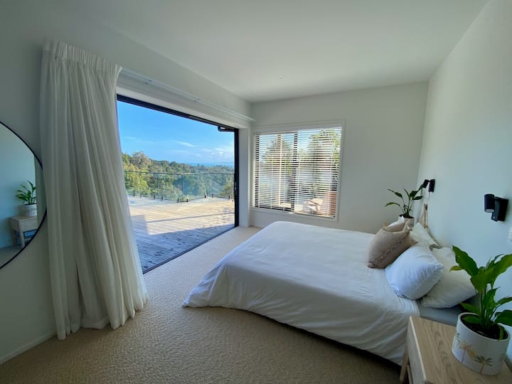 Encantador dormitorio moderno, con baño privado, vestidor, vistas al mar y a los arbustos.
