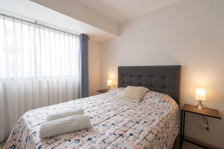 房间内有舒适的床垫，配有深色百叶窗和精美的床上用品套装，让您休