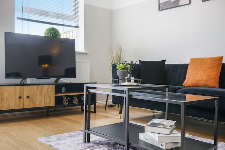 Стилски уреден салон со паметен телевизор и живописни перничиња