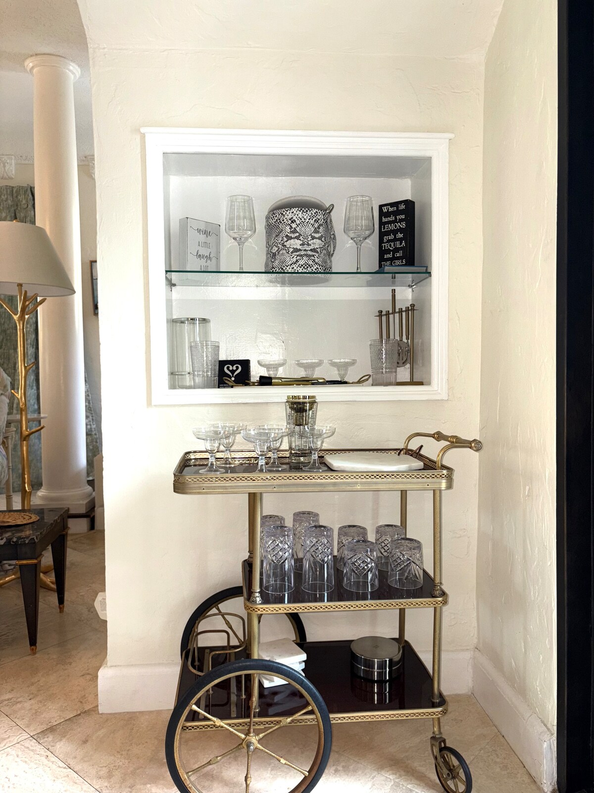 This stylish bar nook features a vintage-inspired cart with glassware and  cocktail tools. It's a fun and functional space, perfect for mixing a drink and adding a touch of charm to your stay.