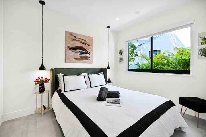 Просторната втора спалня предлага спокойна гледка към градината през живописен прозорец. Насладете се на удобно легло с спално бельо в хотелски стил, стилно висящо осветление и достатъчно пространство в килера с вградени организатори и осветление за допълнително удобство.