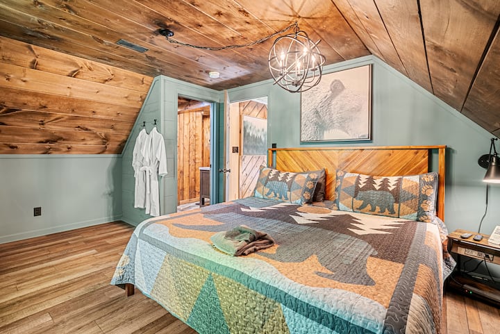 Primary Bedroom Retreat includes a king bed, Roku TV, blackout curtains, a spacious walk-in closet, a private luxurious bathroom, and an exclusive bourbon and coffee wet bar with access to your own private balcony.