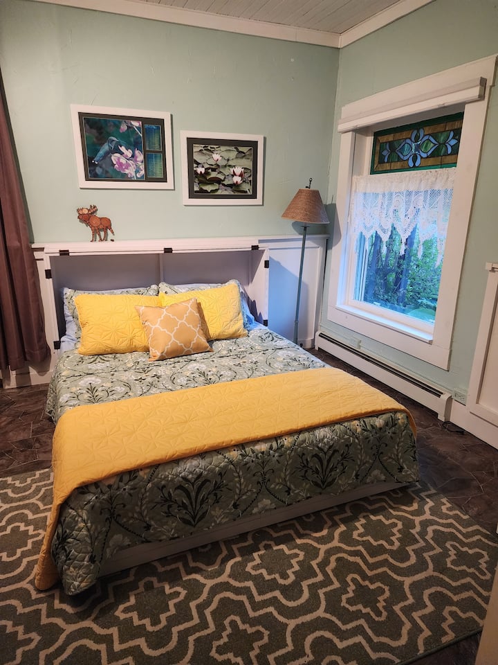 Bedroom #4 is on the main floor and has a queen sized murphy bed plus seating area and work space. This is a mostly private room; curtains in the back of the room separate it from the stairway.