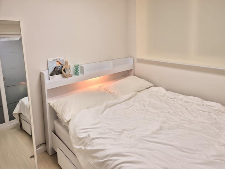 It is a spacious queen-sized bed, and you can use the lights and outlets attached to the bed as standard.
There is a large mirror next to the bed.