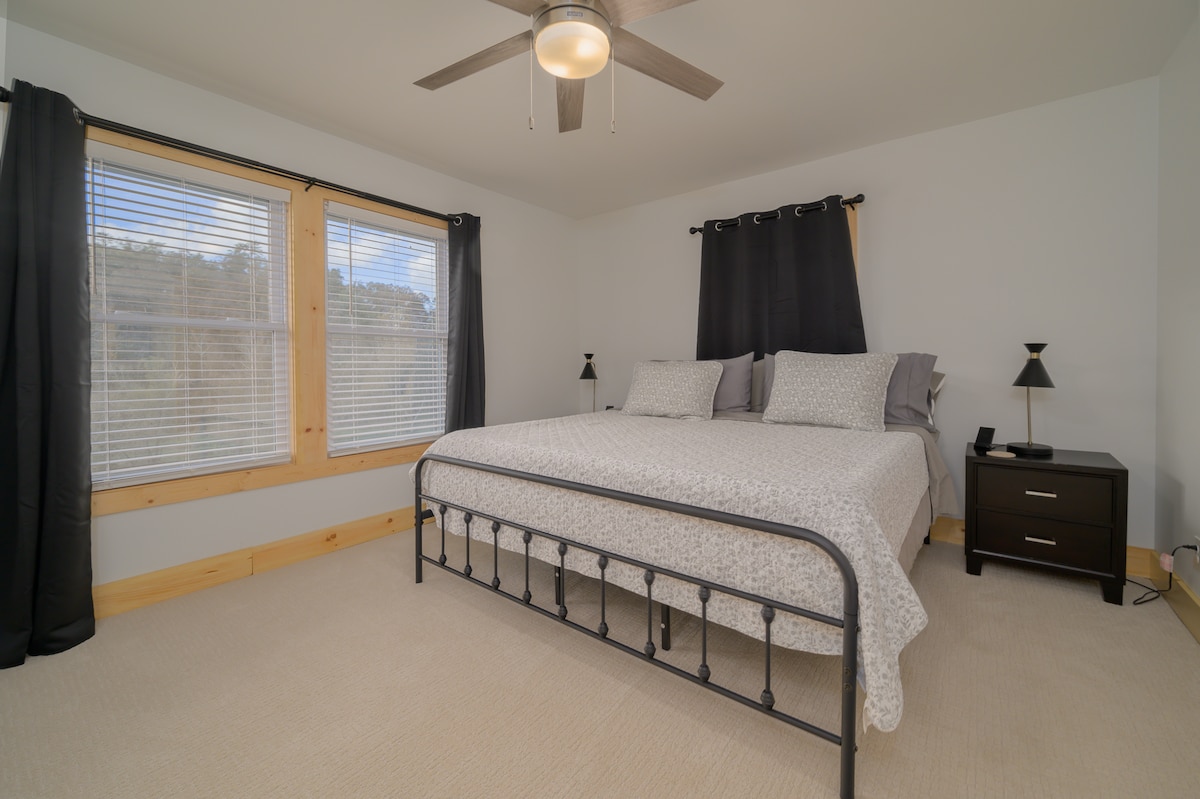 Bedroom 3 features a luxurious king bed and en-suite. Minimalist decor, clean lines, and pops of contrast offer a serene, sophisticated space perfect for a restful stay. 