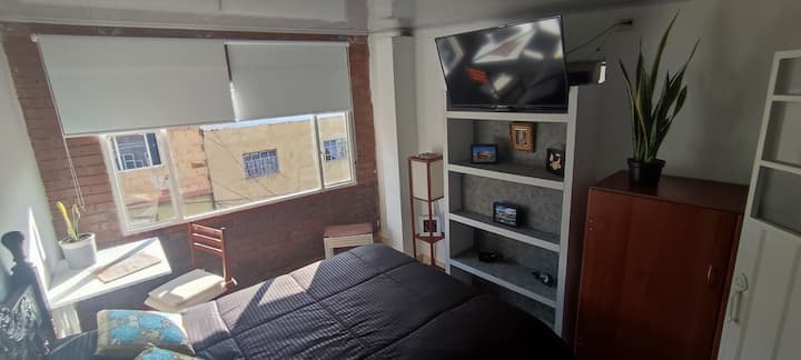Habitación con cama doble (matrimonial) 1.40cm x 1.90cm, televisor con servicio de operador claro. 
Mueble guardarropa con ganchos. Lámpara de piso. 1 mesa de noche. Mesa plegable, adosada a pared apta para trabajo en sitio.