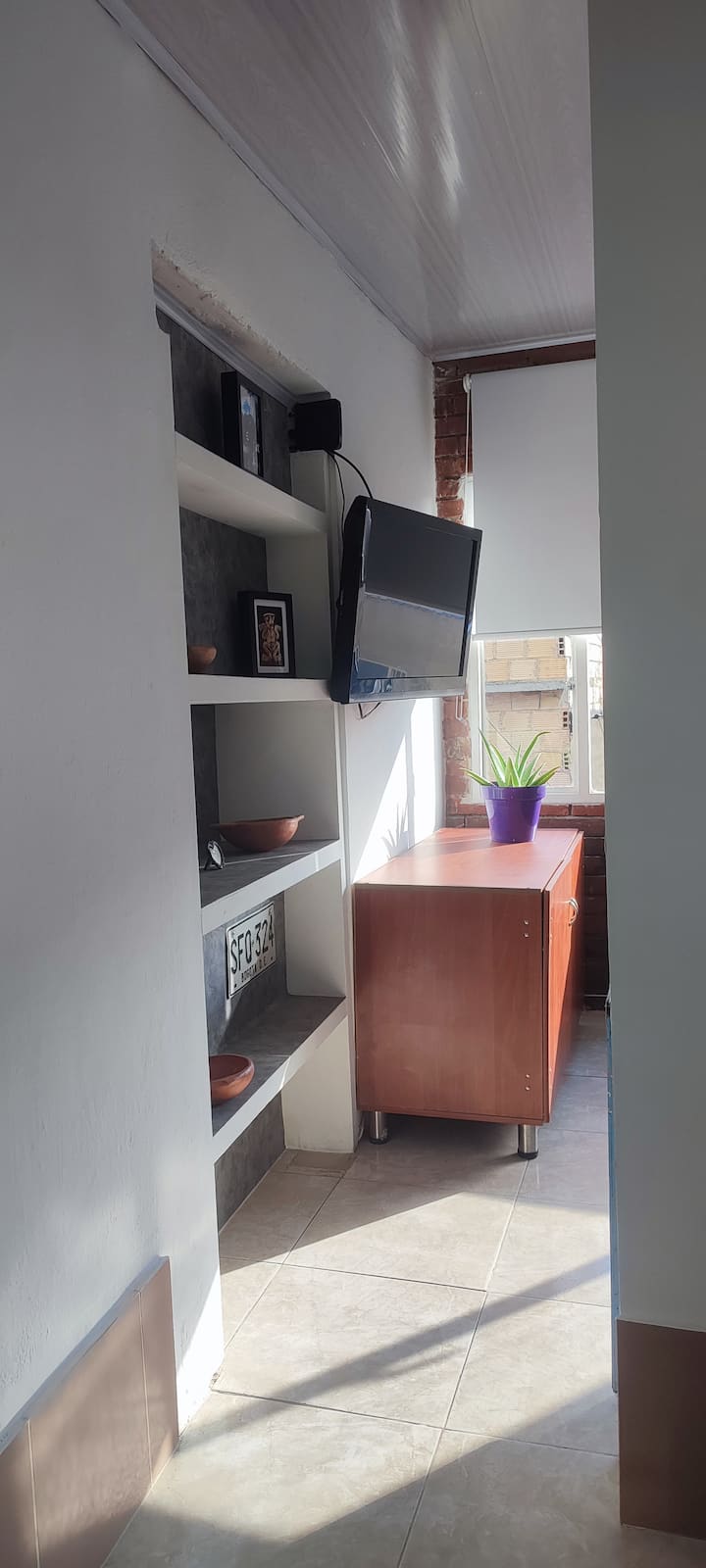 Habitación con cama sencilla 0.90cm x 1.90cm, televisor con servicio de operador claro. 
Mueble guardarropa para linos. Lámpara de mesa. 1 mesa de noche. Sin puerta.
