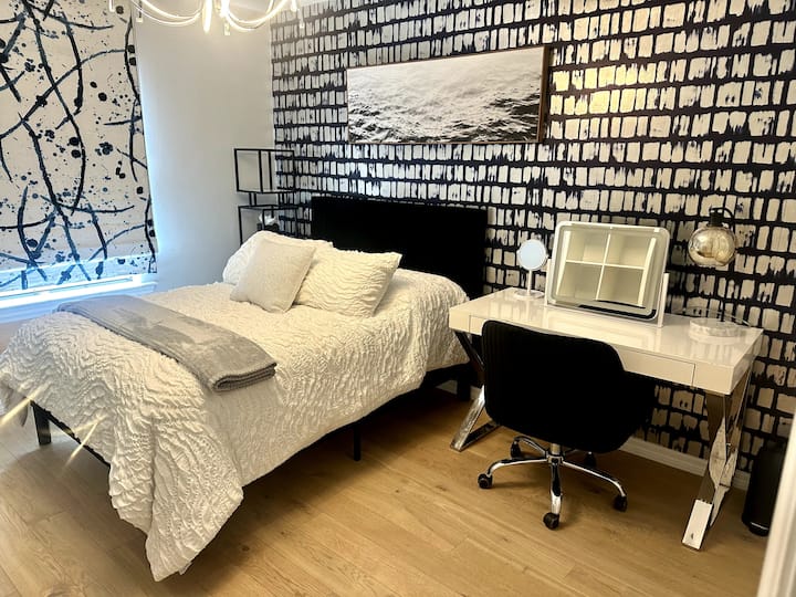 Dormitorio en la planta alta con cama de tamaño completo, escritorio/tocador con espejo, vestidor con cajones, espejo de pared, persiana opaca, armario con amplios colgadores y TV de 50 pulgadas.