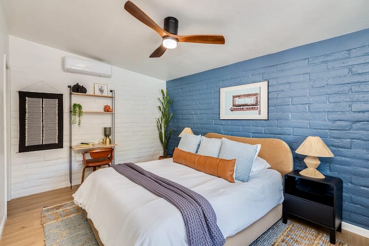 This bedroom is located in the adjacent bungalow and includes a Queen bed, desk & desk chair as well as ceiling fan, bedside lamps, phone charging dock, alarm clock with sound machine and blackout curtains. 