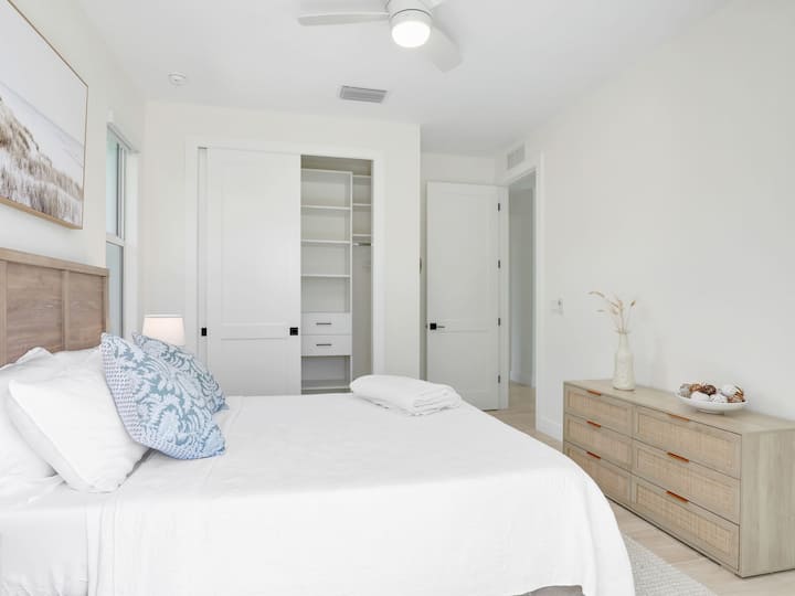 ห้องพักมีเตียงขนาดควีนไซส์โต๊ะข้างเตียงและโคมไฟสร้างบรรยากาศที่เงียบสงบ สีสันที่นุ่มนวลทำให้เกิดความสงบของทะเลในขณะที่งานศิลปะบนพืชพรรณริมชายหาดช่วยเพิ่มความเป็นธรรมชาติและผ่อนคลาย นอกจากนี้ยังมีพื้นที่ตู้เสื้อผ้าเพียงพอสำหรับเก็บของ