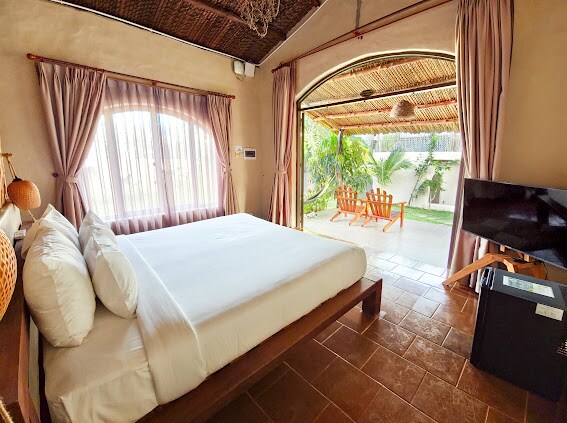 Соба во бунгалов со поглед кон градината среде зелена природа каде што можете да ги слушате птиците како пеат секое утро. Мирна, отворена просторија со пространа тенда идеална за опуштање, читање книга или уживање во шолја кафе на свеж воздух.