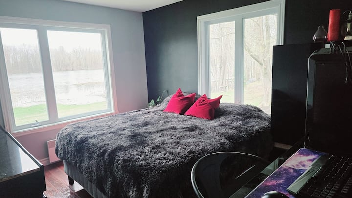 חדר שינה בקומה הראשית עם נוף יפהפה לאגם בחצר האחורית וליער. כולל מיטת קינג סייז ופינת מחשב קטנה עם מסך, מקלדת ועכבר. הוספנו לאחרונה תריסי האפלה.