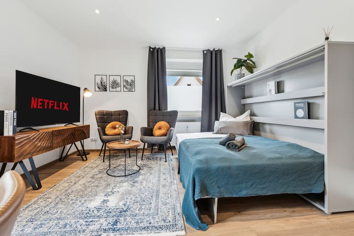 غرفة المعيشة لدينا مغمورة بالضوء
مع شاشة مسطحة. 
يوجد مكان مريح 
منطقة لتناول الطعام لأمسيات مريحة.
بالإضافة إلى ذلك، يوفر سرير الخزانة المريح خيارًا آخر للنوم.