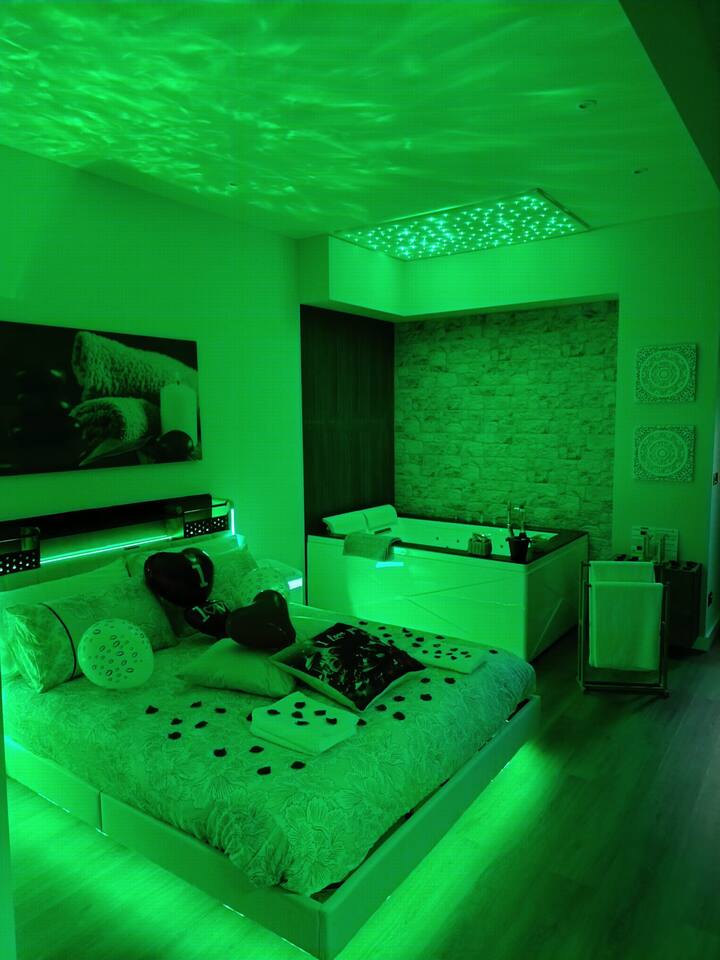 جناح مع جاكوزي وساونا وسرير علاج بالألوان وإعداد رومانسي.