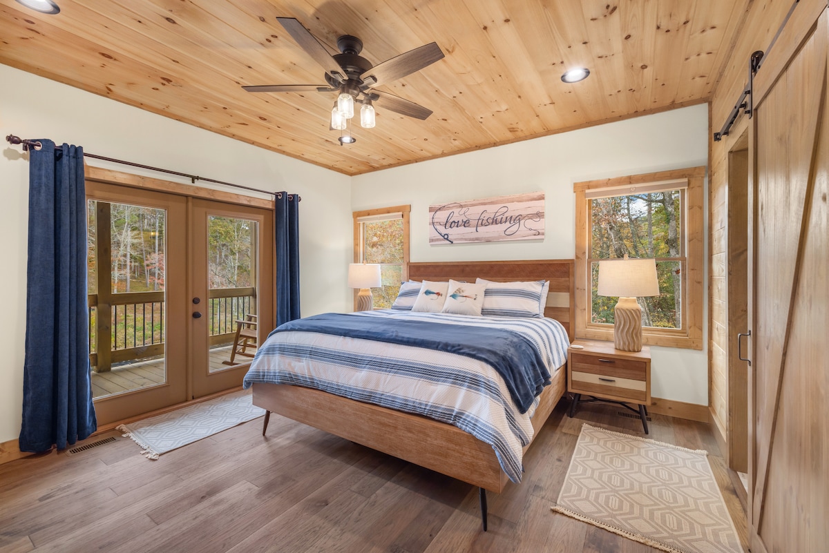 Chambre principale avec lit King Size de niveau principal avec salle de bain privée, télévision connectée et accès direct à la terrasse principale.