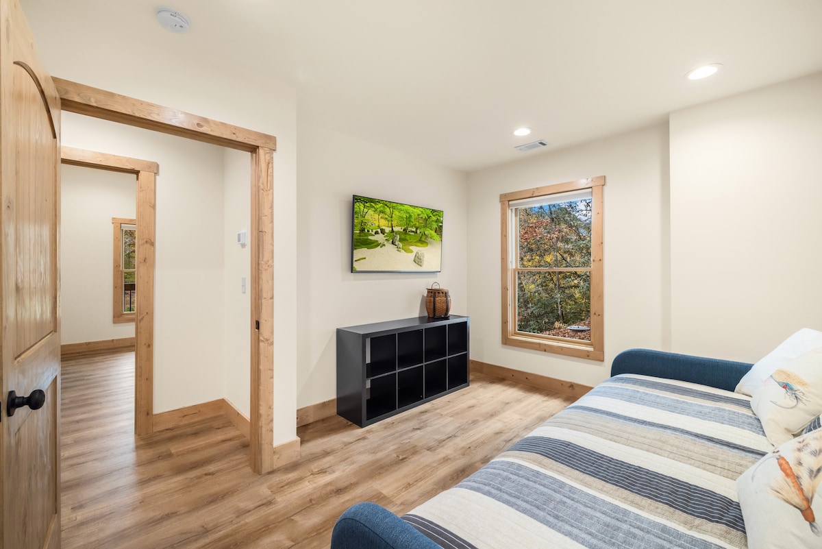 Chambre de plain-pied avec lit gigogne double et télévision connectée