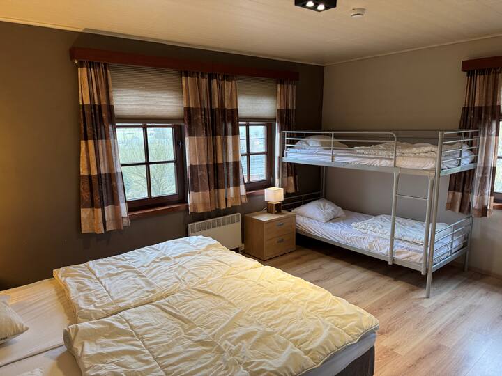 Dormitorio con 2 camas de somier y 1 litera. También se proporciona una pequeña cuna de madera aquí.