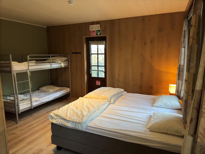 Dormitorio con 2 camas de somier y 1 litera. Lavabo y baño cerrado con ducha.