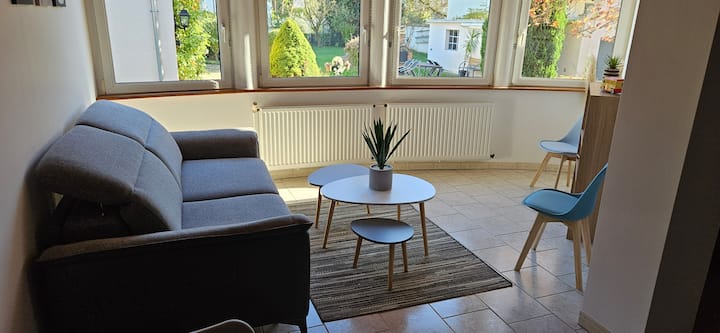 Vardagsrum, med stor bäddsoffa och utsikt över trädgården