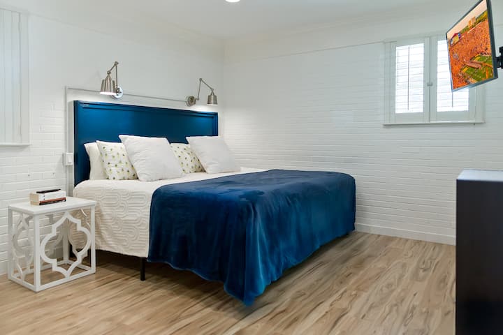 מיטת קינג סייז בחדר השינה 1 עם טלוויזיה מותקנת ומכונת סאונד. 