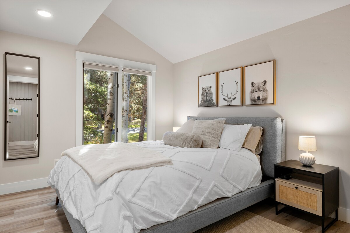 חדר שינה ראשי עם מיטת קווין סייז ומטענים משני הצדדים