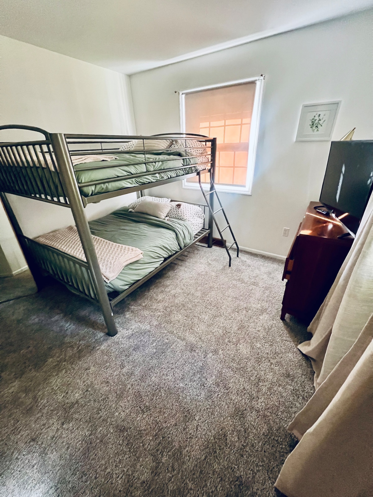 أسرّة مزدوجة بطابقين في الطابق الأول مع خزانة وخزانة ملابس كبيرة ومروحة صندوقية وتلفزيون ذكي.