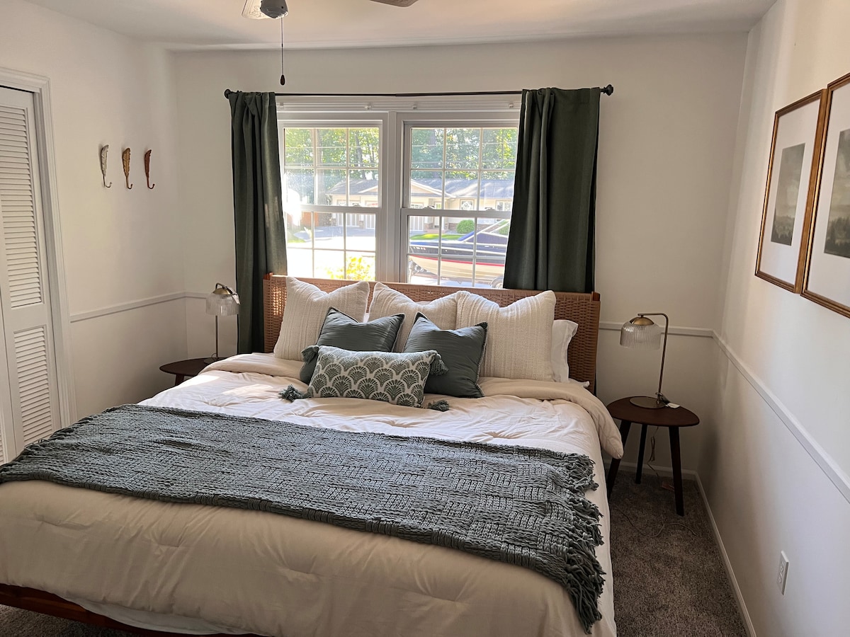 غرفة نوم في الطابق الأول بسرير كينج قياسي وخزانة كبيرة وشرفة سقف.