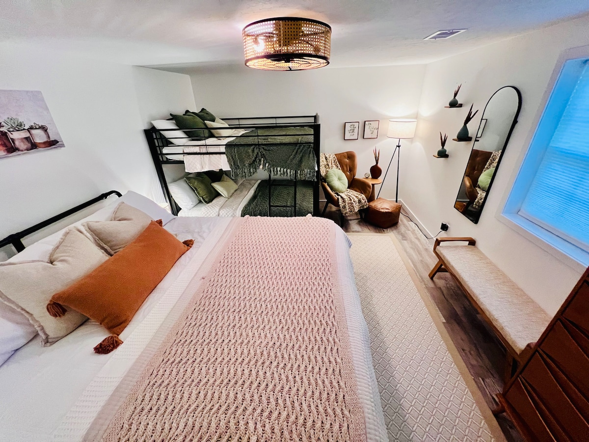 غرفة نوم رابعة كبيرة في الطابق السفلي مع سرير كاليفورنيا كينغ وسرير مزدوج بطابقين.  كما تحتوي على زاوية قراءة مريحة.