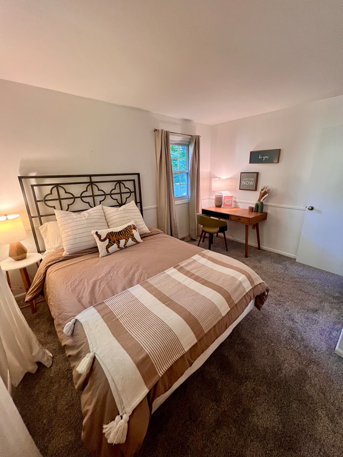 غرفة نوم في الطابق الأول بسرير بمقاس كبير ومساحة عمل مع مكتب ومصباح.