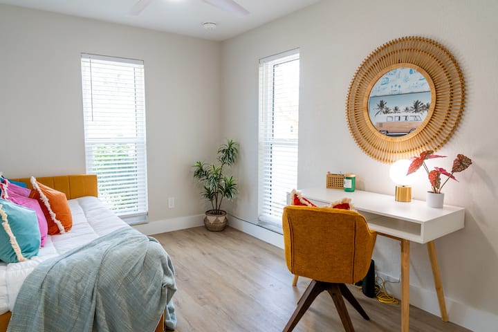 Office workspace and bedroom with two twin beds