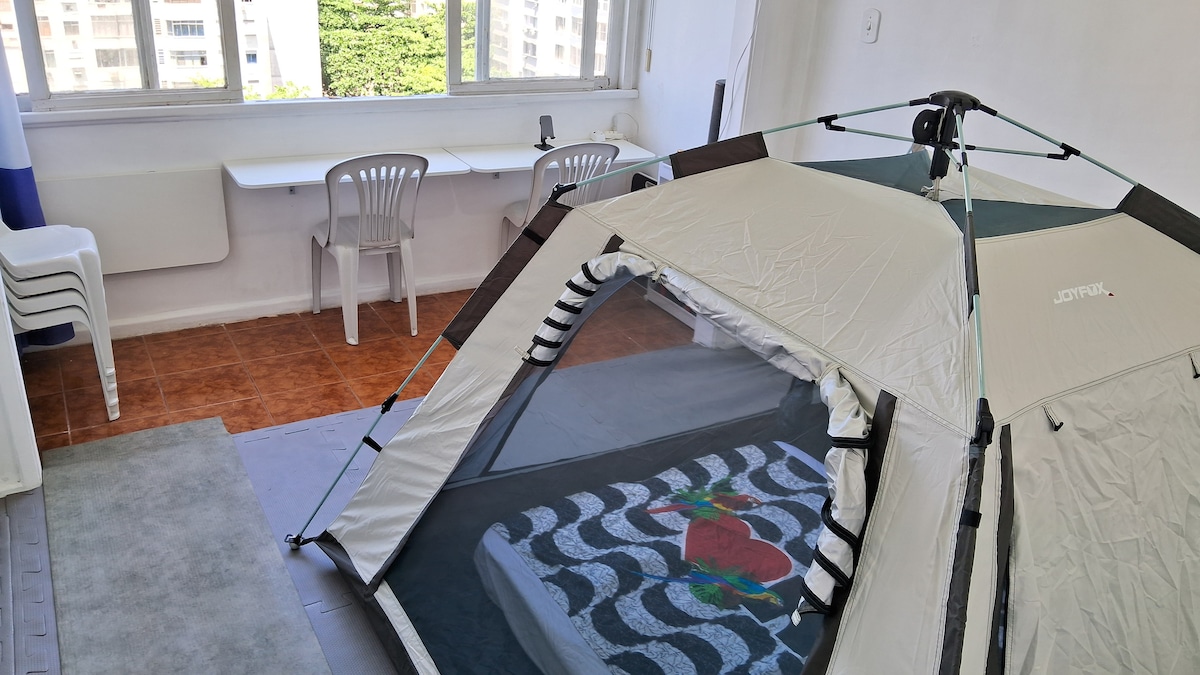** BARRACA/TENDA privativa (não é um 'quarto' privativo com paredes, como o título padrão do Airbnb sugere) em uma sala compartilhada **