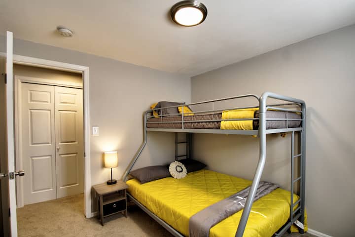 una litera con una parte inferior doble y una parte superior individual, ideal para familias o grupos. Luminoso y minimalista, con barandillas de seguridad, sábanas suaves y una escalera estable, perfecta para una estancia cómoda y funcional.