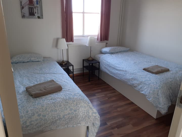 The front bedroom with two beds, chest of drawers