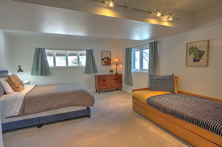 Spálňa s manželskou posteľou typu queen na poschodí s dvojitou posteľou, ktorá má ďalšiu oddelenú posteľ, ktorá sa vysúva zdola.