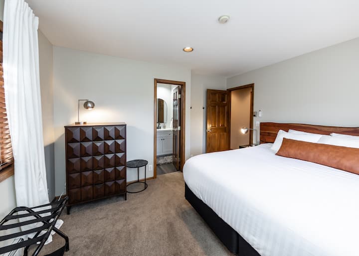 Otro dormitorio con ropa de cama acogedora y vestidor.