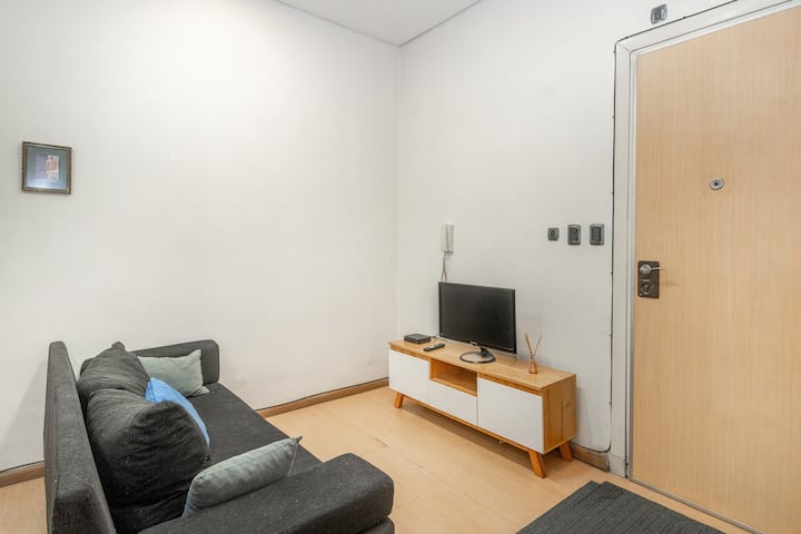 Udoban dnevni boravak.  Fotelja, stalak, TV. 