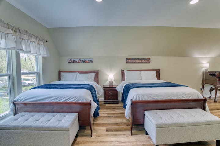 חדר נעים עם שתי מיטות קווין סייז, לכל מיטה יש ספסל מרופד לרגליים ושידת לילה עם מנורה ביניהם. ליד חלון, ושולחן עבודה קטן מעץ עם כיסא בפינה. מושלם למנוחה או לעבודה.