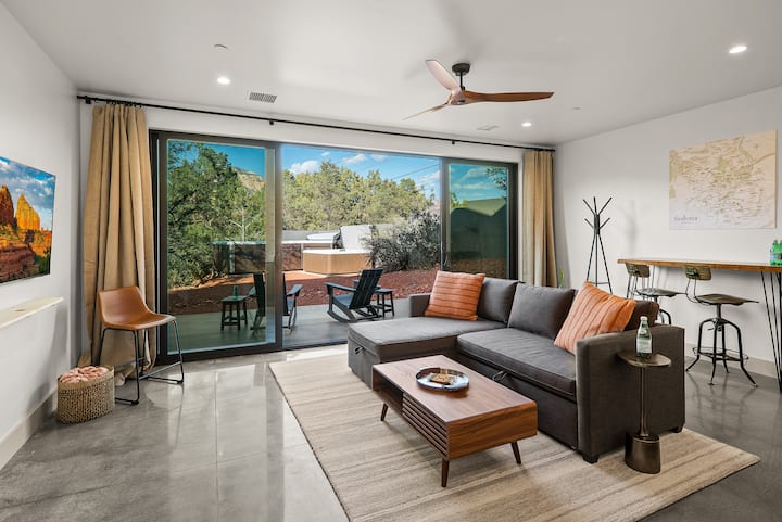 エレベーターは上下の階をつないでいます。 階下の汎用性の高いリビングスペースは、焚き火台、露天風呂・ジャグジー、スイムスパを備えた並木道のパティオに面しています。 